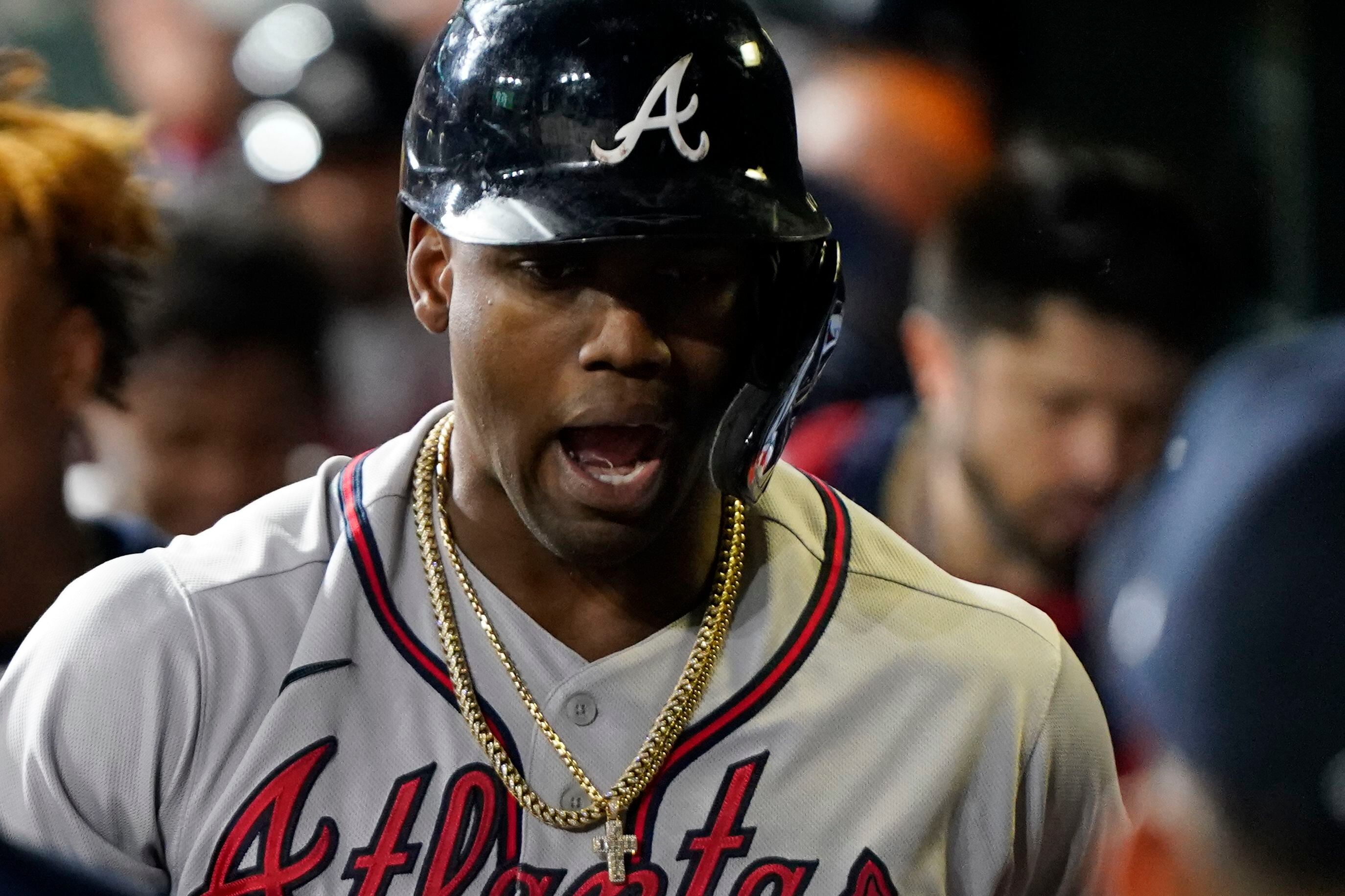 Miami Marlins' Jorge Soler holds up a chain necklace in the dugout